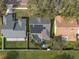 Aerial shot displays a house with solar panels and a screened pool, nestled among mature trees at 9415 Pebble Glen Ave, Tampa, FL 33647