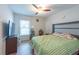 Cozy bedroom with wood-look flooring, ceiling fan, and natural light at 9415 Pebble Glen Ave, Tampa, FL 33647