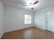 Well-lit bedroom featuring hardwood floors, a bright window, and a ceiling fan at 9415 Pebble Glen Ave, Tampa, FL 33647