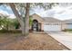 Charming single-story home featuring a manicured lawn, two-car garage, and mature trees at 9415 Pebble Glen Ave, Tampa, FL 33647