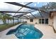 A screened-in pool with crystal clear water offers a private outdoor retreat in this charming backyard at 9415 Pebble Glen Ave, Tampa, FL 33647