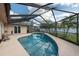 Inviting swimming pool with a screened enclosure surrounded by palm trees and privacy fencing at 9415 Pebble Glen Ave, Tampa, FL 33647