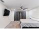 This bedroom features a ceiling fan, mounted TV, and natural light at 10424 Gifford Dr, Spring Hill, FL 34608