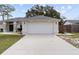 A home with a two-car garage and a concrete driveway that provides ample parking space at 10424 Gifford Dr, Spring Hill, FL 34608