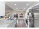 Spacious kitchen with stainless steel appliances, white cabinets, granite countertops, and wood flooring at 10424 Gifford Dr, Spring Hill, FL 34608