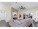 Inviting living room with a stacked stone fireplace, modern ceiling fan, and large windows for natural light at 10424 Gifford Dr, Spring Hill, FL 34608