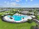 Aerial view of the community pool and amenity center with palm trees, lounge chairs and manicured landscaping at 10920 Green Harvest Dr, Riverview, FL 33578