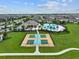 Aerial view of community amenities: pool, clubhouse, tennis courts, with lush landscaping, and convenient parking at 10920 Green Harvest Dr, Riverview, FL 33578