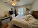 Bright bedroom featuring a large window with white curtains and a comfortable queen bed at 1151 Thayer St, Safety Harbor, FL 34695