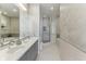 Bright bathroom featuring dual sinks, walk-in shower, soaking tub, and decorative tile accents at 1209 E Cumberland Ave # 2802, Tampa, FL 33602