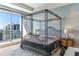 Stunning bedroom boasts a wrought iron canopy bed, city views, and abundant natural light from large windows at 1209 E Cumberland Ave # 2802, Tampa, FL 33602