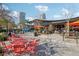 Outdoor seating area with modern tables and chairs, landscaping, and nearby buildings with balconies at 1209 E Cumberland Ave # 2802, Tampa, FL 33602