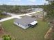 Aerial view of a single-story home highlighting the manicured lawn, screened-in porch, and surrounding landscape at 12341 Filbert Rd, Weeki Wachee, FL 34614