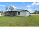 Expansive backyard features lush green grass, a screened-in lanai, and views of the surrounding landscape at 12341 Filbert Rd, Weeki Wachee, FL 34614
