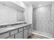 Modern bathroom featuring double sinks, granite countertops, stylish vanity and sleek, marble-tiled shower at 12341 Filbert Rd, Weeki Wachee, FL 34614