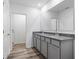 Bathroom showcasing double sinks, granite countertops, and wood-look flooring, radiating a fresh, modern appeal at 12341 Filbert Rd, Weeki Wachee, FL 34614