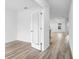 Bright bedroom view shows wood-look floors, white walls, trim, and a doorway leading to the main living space at 12341 Filbert Rd, Weeki Wachee, FL 34614