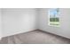 Bright bedroom featuring a window providing natural light and neutral carpet at 12341 Filbert Rd, Weeki Wachee, FL 34614