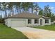 Charming single-story home features a well-maintained lawn, neutral paint, a two-car garage, and classic black shutters at 12341 Filbert Rd, Weeki Wachee, FL 34614