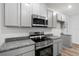 Close up of the modern oven and microwave with granite countertops in the kitchen at 12341 Filbert Rd, Weeki Wachee, FL 34614