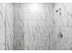 Close-up of a shower with marble-patterned tile, chrome fixtures, providing a luxurious spa-like feel at 12341 Filbert Rd, Weeki Wachee, FL 34614
