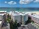 Aerial view of a beachfront condo with a parking lot, beach access, and stunning water views at 12924 Gulf Blvd # 503, Madeira Beach, FL 33708
