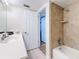 Bathroom featuring a white vanity, a shower with tan tiling, and a doorway to the bedroom at 12924 Gulf Blvd # 503, Madeira Beach, FL 33708