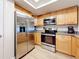 Well-equipped kitchen featuring stainless steel appliances and ample wood cabinetry with modern lighting at 12924 Gulf Blvd # 503, Madeira Beach, FL 33708