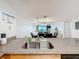 Granite countertop with sink and view into the living area and balcony with ocean view at 12924 Gulf Blvd # 503, Madeira Beach, FL 33708