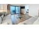 Comfortable living room with sliding glass doors to balcony, and light wood-look floors at 12924 Gulf Blvd # 503, Madeira Beach, FL 33708