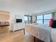 Bright bedroom with ocean view, balcony access, dresser, and a glimpse of the living room at 12924 Gulf Blvd # 503, Madeira Beach, FL 33708