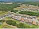 Expansive aerial view showcasing a community with tree-lined streets, backyard pools, and scenic green spaces at 13069 Paddock Wood Pl, Riverview, FL 33579