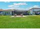 Expansive backyard with a fire pit, seating area, mature landscaping, and plenty of green space at 13069 Paddock Wood Pl, Riverview, FL 33579