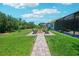 Spacious backyard with a paver patio, fire pit, mature landscaping, and a well-manicured lawn at 13069 Paddock Wood Pl, Riverview, FL 33579