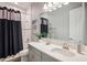 Modern bathroom featuring a gray vanity, quartz countertop, framed mirror, and shower-tub combo at 13069 Paddock Wood Pl, Riverview, FL 33579