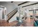 Dining area with a modern glass table, designer chairs, and wood-look flooring near kitchen and staircase at 13069 Paddock Wood Pl, Riverview, FL 33579