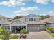 Beautiful two-story home with a brick driveway, manicured landscaping, three-car garage and covered front porch at 13069 Paddock Wood Pl, Riverview, FL 33579
