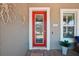 Inviting red front door complemented by decorative accents and manicured landscaping, creating a warm welcome at 13069 Paddock Wood Pl, Riverview, FL 33579
