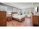 Bright main bedroom features a tray ceiling, plantation shutters, and wood furniture at 13069 Paddock Wood Pl, Riverview, FL 33579