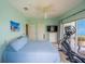 Bedroom with a large bed and ensuite bathroom with ocean view, plus a large elliptical exercise machine at 13105 Boca Ciega Ave, Madeira Beach, FL 33708