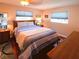 Cozy bedroom featuring a comfortable bed, wood floors, and natural light from two windows at 1363 Overlea Dr, Dunedin, FL 34698