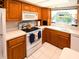 Kitchen with all white appliances, wood cabinets, and neutral countertops at 1363 Overlea Dr, Dunedin, FL 34698