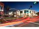 A well-lit street at night with an archway that says 