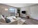 Open living room with light gray walls, wood floors, a modern sofa, and access to the balcony at 1400 Gandy N Blvd # 502, St Petersburg, FL 33702
