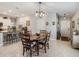 Cozy dining area featuring an elegant light fixture, and a view into the kitchen with barstool seating and tiled floor at 15454 Miller Creek Dr, Sun City Center, FL 33573