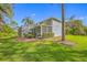 Backyard featuring a screened-in lanai and lush lawn, perfect for outdoor entertaining and relaxation at 15702 Muirfield Dr, Odessa, FL 33556