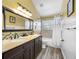 Bathroom featuring double sinks, granite counters, soaking tub with tiled surround, and neutral decor at 15702 Muirfield Dr, Odessa, FL 33556