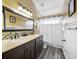 Bright bathroom with double vanity, granite countertop, and decorative backsplash at 15702 Muirfield Dr, Odessa, FL 33556
