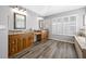 Spacious bathroom with double vanity, natural light, and elegant wood-look tile flooring at 15702 Muirfield Dr, Odessa, FL 33556