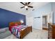Bedroom featuring a colorful bedspread, plush carpet, with a view of the ensuite bathroom and closet at 15702 Muirfield Dr, Odessa, FL 33556